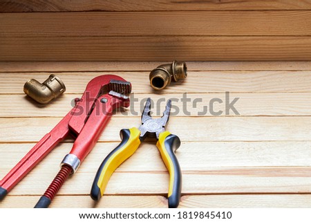 plumbing tools and accessories for adjusting pipe leak. wooden desk background. plumber service concept. fixing house problems.
