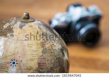 Close-up on a world map with a camera in the background