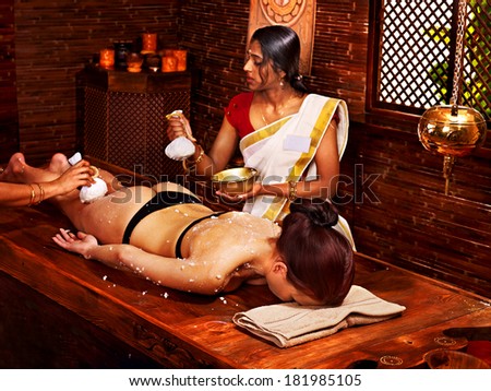 Woman having Ayurveda massage with pouch of rice.