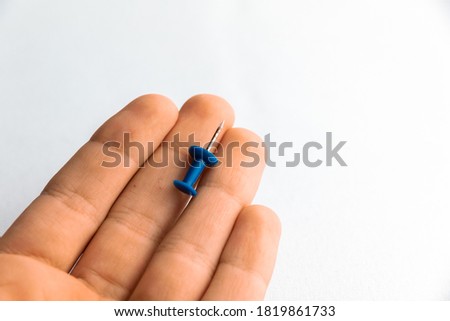 Blue pin in the hand of a teenager
