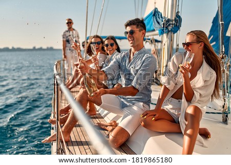 Group of friends relaxing on luxury yacht and drinking champagne. Having fun together while sailing in the sea. Traveling and yachting concept. Royalty-Free Stock Photo #1819865180