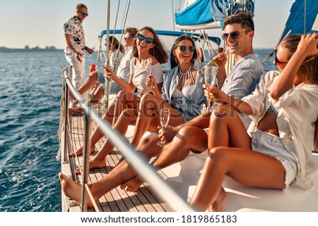 Group of friends relaxing on luxury yacht and drinking champagne. Having fun together while sailing in the sea. Traveling and yachting concept. Royalty-Free Stock Photo #1819865183