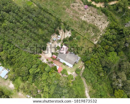 Panoramic aerial view of a few village homes with surrounding trees
