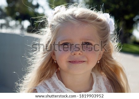 beautiful little girl in a white dress as a portrait closeup