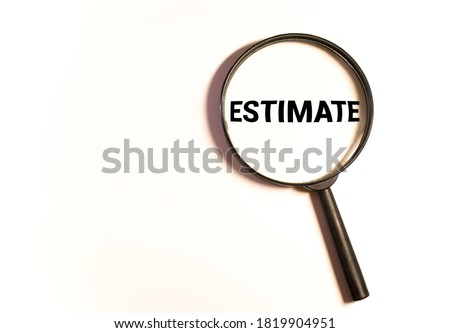 Estimates. The inscription on wooden blocks Through a magnifying glass on a blue background. Isolated.