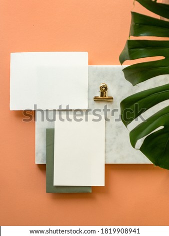 Tropical stationery Invitation Card and envelope Mock up with white, uncoated paper sheets and tropical monstera leaves