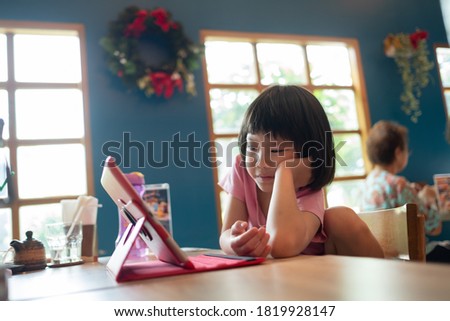 kid is addicted to tablet, little girl playing smartphone, kid use telephone, watching cartoon
