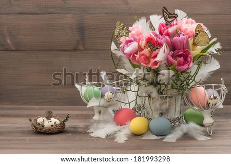 Easter decoration with pink tulips, butterflies and colored eggs. Spring flowers