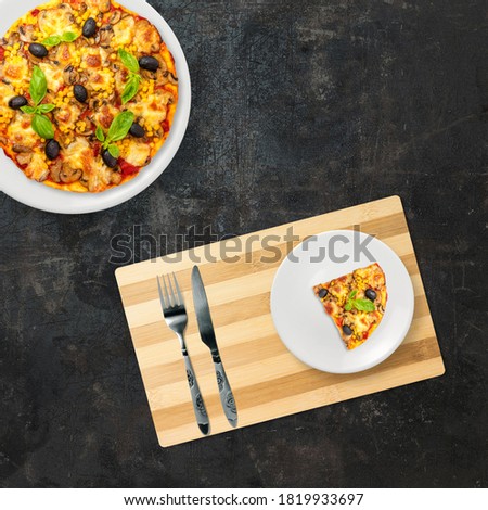 Top view of fast food on a dark background . Stock photo of a pizza and a table with a dish, fork and a knife. American food. Composition of fast food on a white background with copy space.
