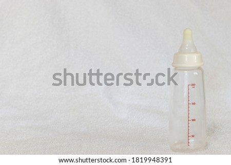 An empty baby bottle on a white towel