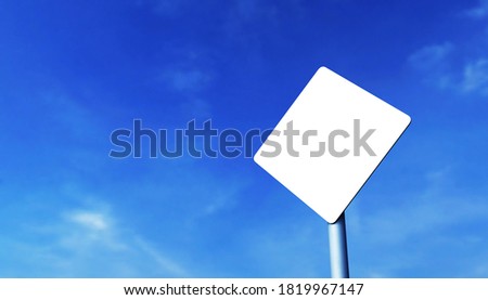 Mockup of a diamond-shaped road sign on a metal pole, against a blue sky