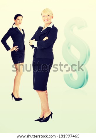Two female lawyers standing next to big paragraph sign