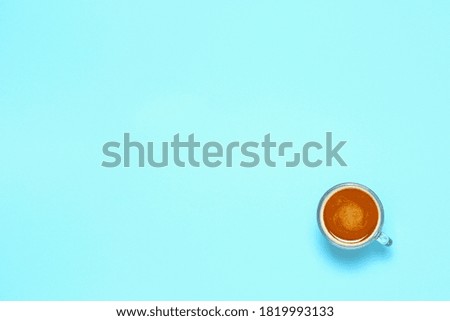 cup of coffee on empty light blue surface, top view with copy space