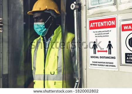 Caution sign in factory warning to industry labor worker to prevent Covid-19 Coronavirus spreading during job business reopening period after epidemic crisis . Working safely concept.