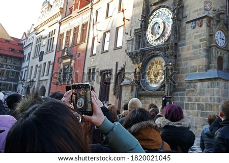 Tourists with smartphones taking picture of famous clocktower Orloj, Prague, Czech Republic