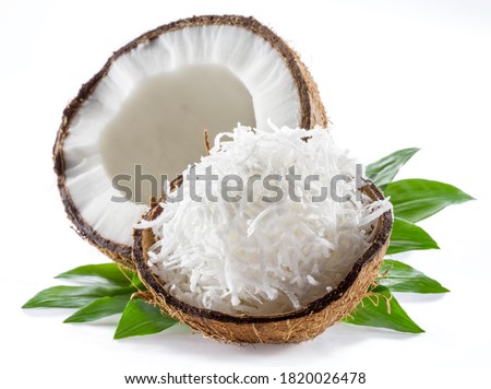 Cracked coconut fruit with white flesh and shredded coconut flakes isolated on white background. Royalty-Free Stock Photo #1820026478