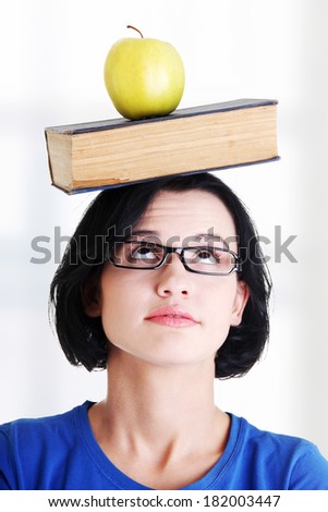 Student with an apple and book on her head