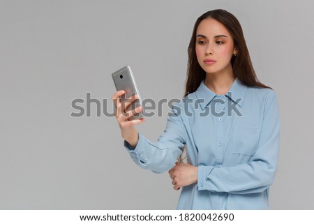 Beautiful young woman is making selfie photo with smartphone.