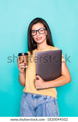 Young confident woman with coffee cup and holding folder isolated on turquoise background.