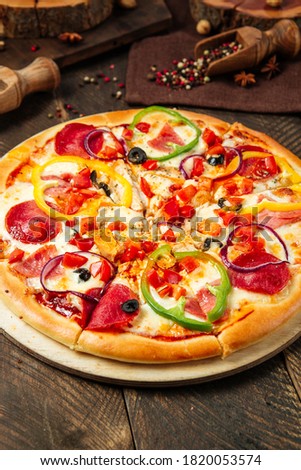 Closeup on pizza with salami and bell pepper on the wooden table