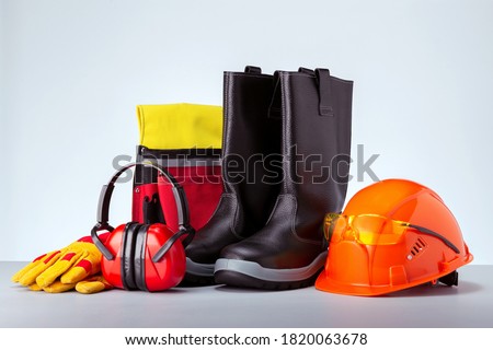 Personal protection equipment against grey background. Concept work safety.  Royalty-Free Stock Photo #1820063678