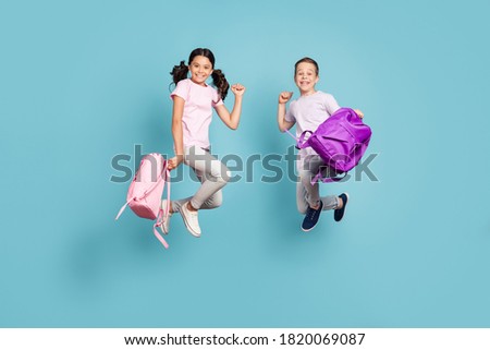 Full length body size view of his he her she nice attractive small little cheerful buddy fellow friends friendship jumping having fun rejoicing good mood isolated blue pastel color background Royalty-Free Stock Photo #1820069087