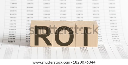 wooden cubes with letters ROI on the chart background