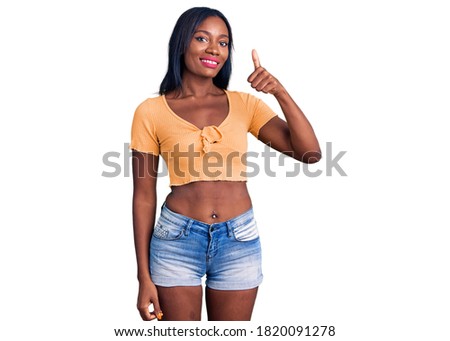 Young african american woman wearing casual clothes smiling happy and positive, thumb up doing excellent and approval sign 