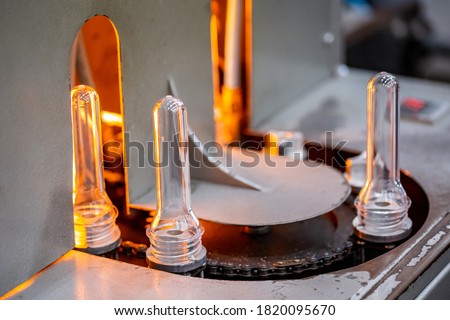 Preforms for making PET plastic bottles. Blank for production of containers for milk or beer. Line factory industry equipment. Royalty-Free Stock Photo #1820095670