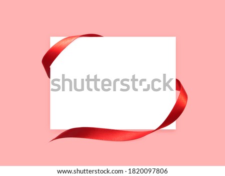 White paper card with red satin ribbon.