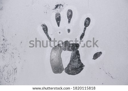 handprint on frozen cold glass