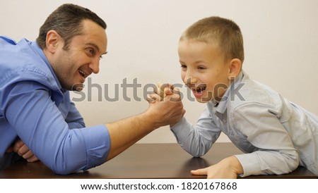 Portrait of father and son arm resting, child beat his parent. roll over 