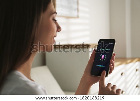 Woman using voice search on smartphone indoors