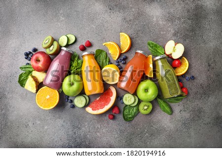 Set of fruit juices in glass bottles on stone background. Top view. Royalty-Free Stock Photo #1820194916