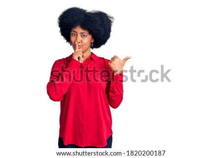 Young african american woman wearing casual clothes asking to be quiet with finger on lips pointing with hand to the side. silence and secret concept. 