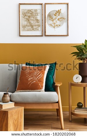 Interior design of modern living room with two mock up poster frames, elegant sofa, plant, pillow and personal accessories in stylish home staging. Honey yellow concept.