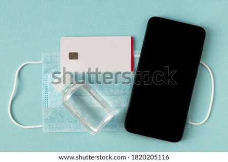 Smartphone on the background of a medical mask and antiseptic gel.
