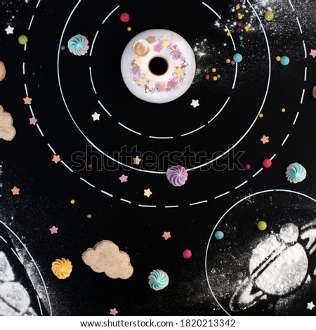 A galaxy with donut, cloud cookies and sprinkles on a black background
