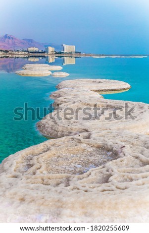 Picturesque white paths from evaporated salt. Azure sea water is full of healing salts. Israel. Concept of ecological, medical and photo tourism. Early morning at the resorts of the Dead Sea