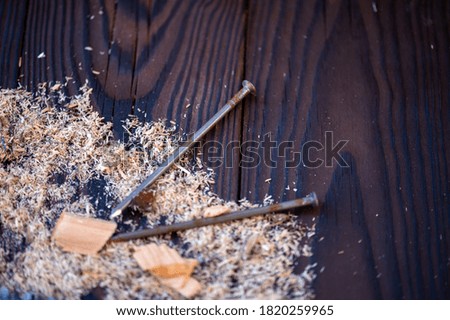 Several nails scattered on a wooden surface, close-up, selective focus.
