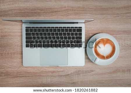 Office desk table with laptop and coffee cup.
