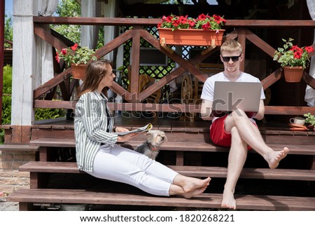 couple of young lovers with york dog Spend time outside countryhouse with laptop communicating in social networks. modern gadgets concept. modern technology in cozy farmhouse Royalty-Free Stock Photo #1820268221