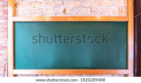 Blank blackboard on plank wooden table top at wall,Template mock up for adding your design and leave space beside frame for adding more content.