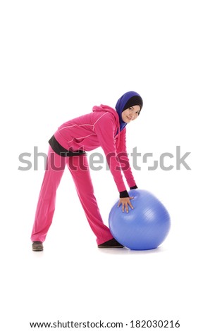 Young fitness muslimah holding a blue ball isolated on white