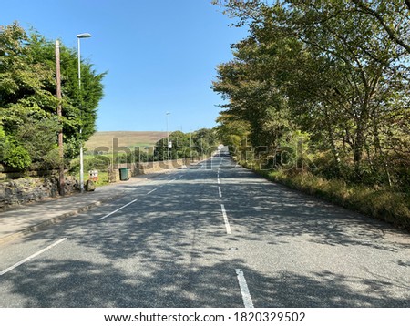 Looking up, the Halifax Road, with old trees, dry stone walls, and hills in the distance near, Rochdale, Lancashire, UK
