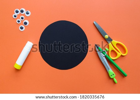 The child creates a black spider decoration. Halloween party. Children's art project. DIY concept. Step-by-step photo instruction. Step 2