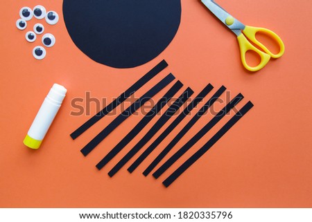 The child creates a black spider decoration. Halloween party. Children's art project. DIY concept. Step-by-step photo instruction. Step 3