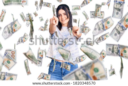 Young beautiful girl wearing casual t shirt pointing to you and the camera with fingers, smiling positive and cheerful