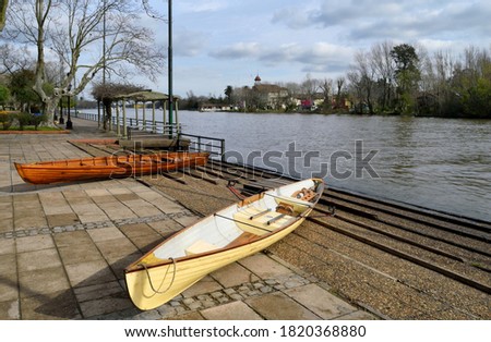 Photography of two rowing boats in a pier at the coast of a stream