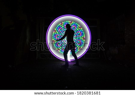 One people standing alone against a Colourful circle light painting as the backdrop